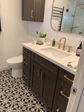 Bathroom remodel, dark brown vanity, white countertop, bronze fixtures, cabinets, tile with pattern